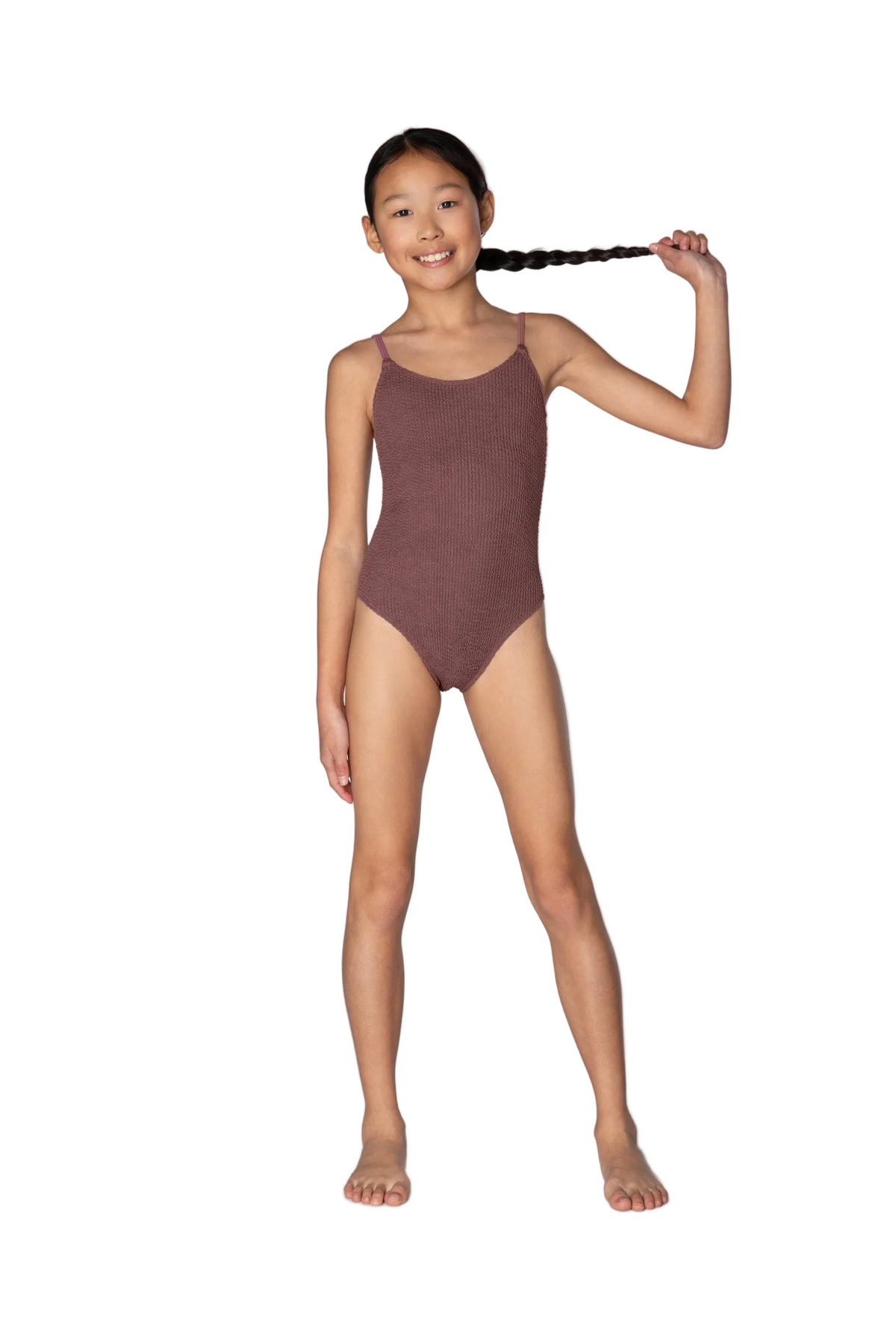 Young girl wearing a maroon swimsuit on a white background