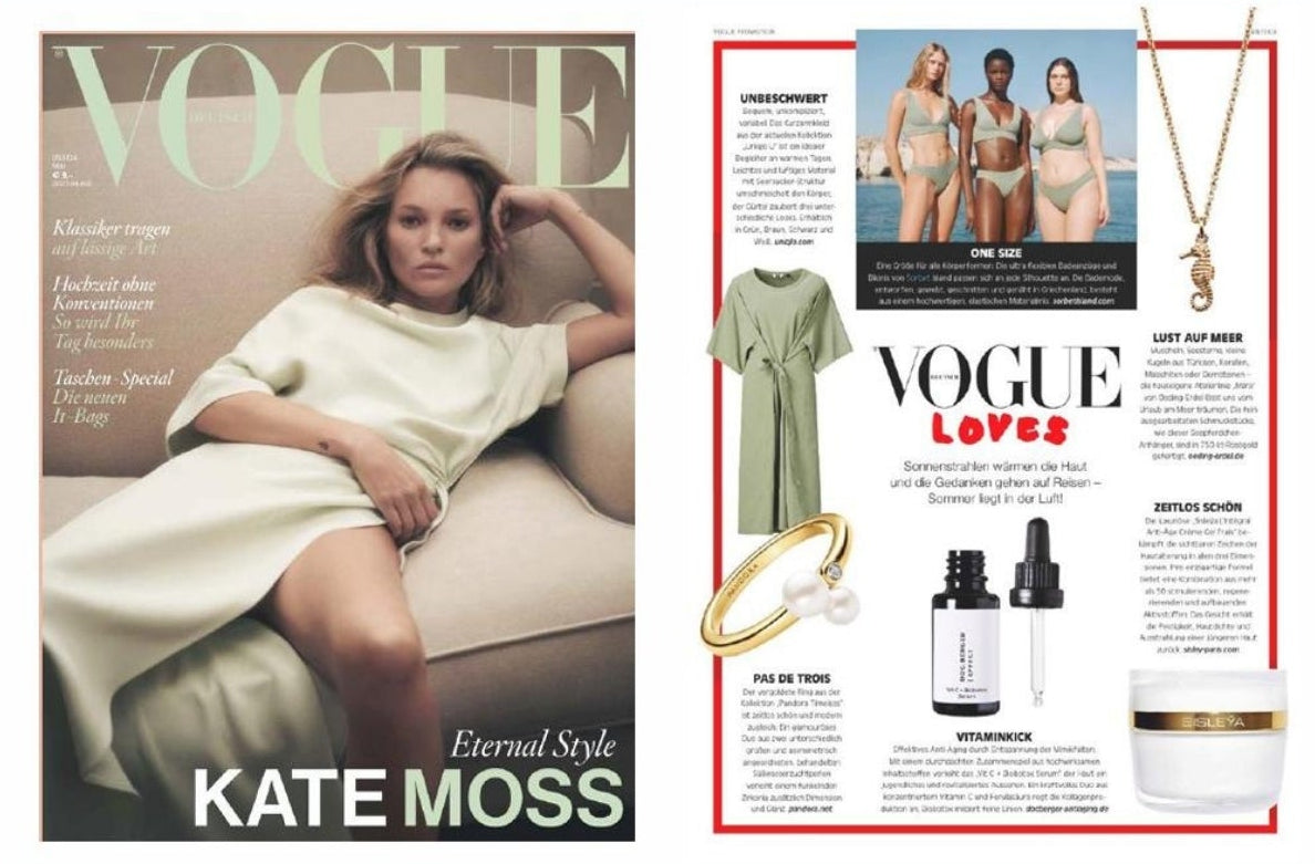 A promotional graphic on a peach background with the text 'STRONG MEDIA PRESENCE IN WORLD PRESS.' The center shows an open magazine spread featuring a Kate Moss Vogue cover and an editorial page with fashion and beauty items, including a green dress, gold jewelry, serum bottles, and a white cosmetic jar.