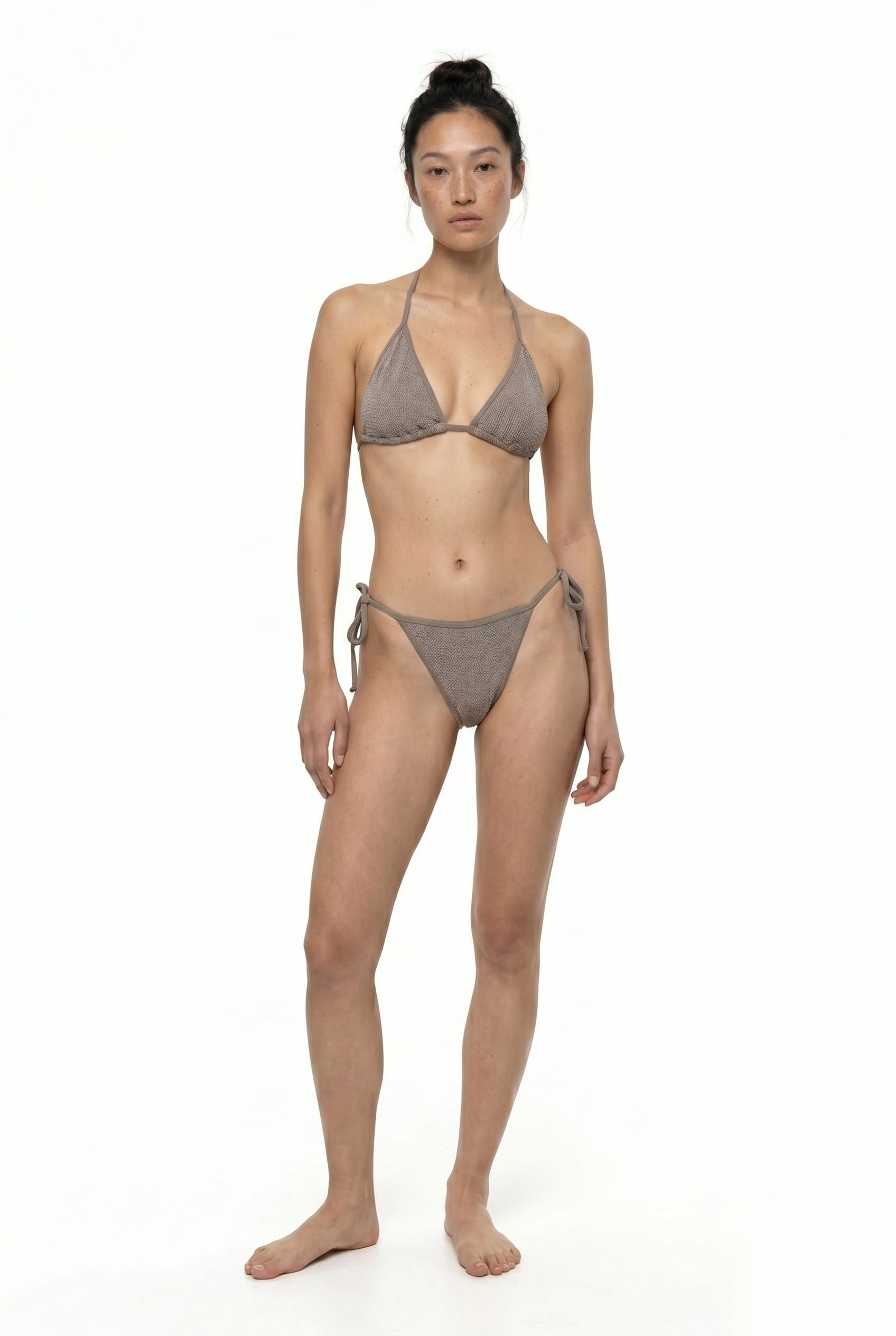 Woman wearing a gray bikini on a white background