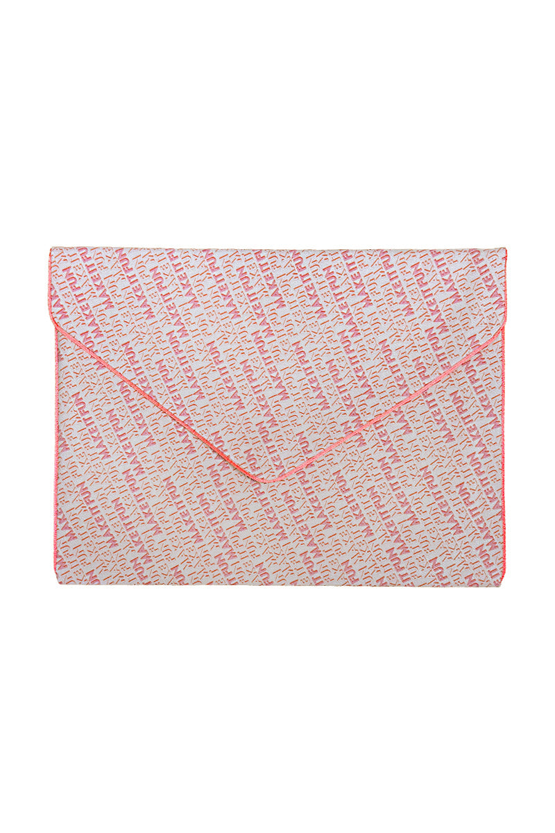 A rectangular envelope-style clutch or pouch with a flap closure, featuring a dense script pattern in coral pink and off-white, finished with a solid coral pink border.