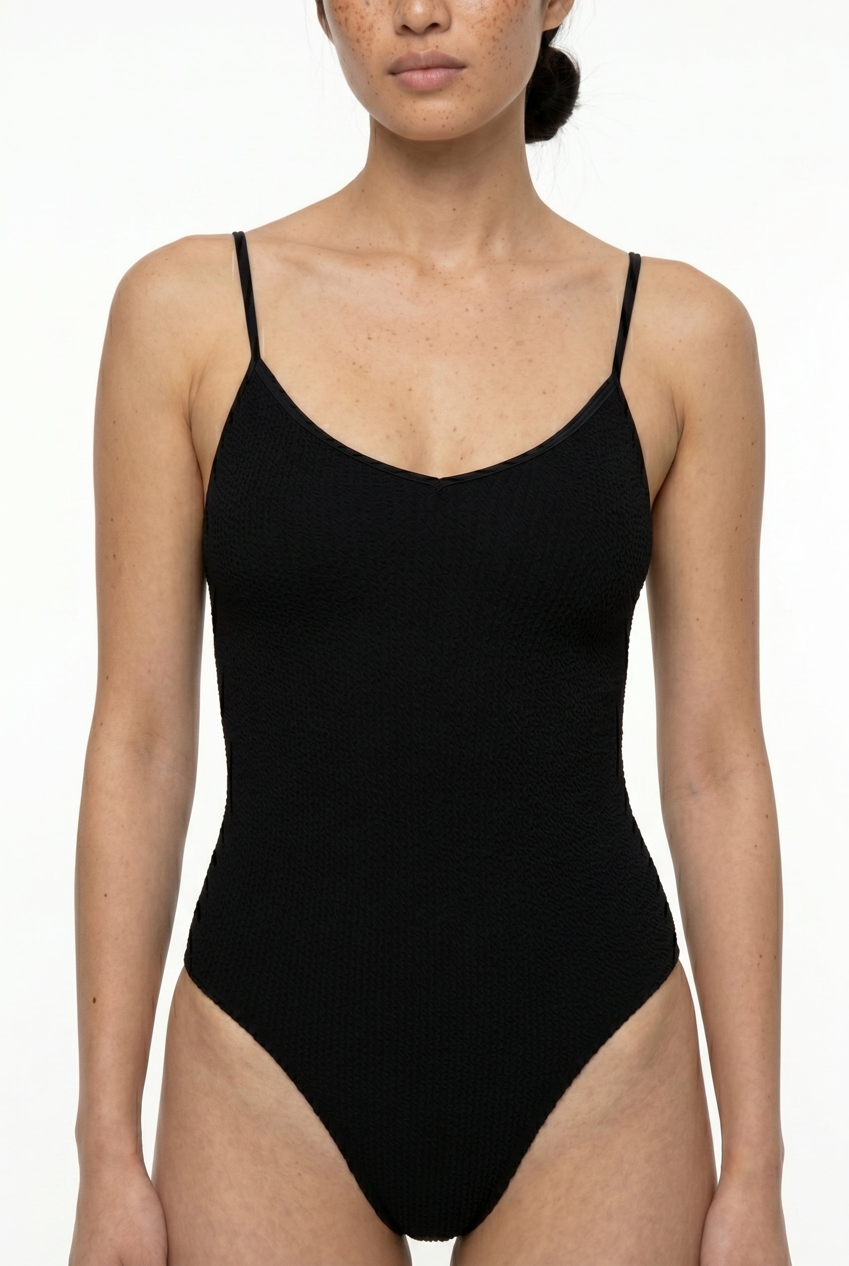 Black one-piece swimsuit worn by a model on a white background