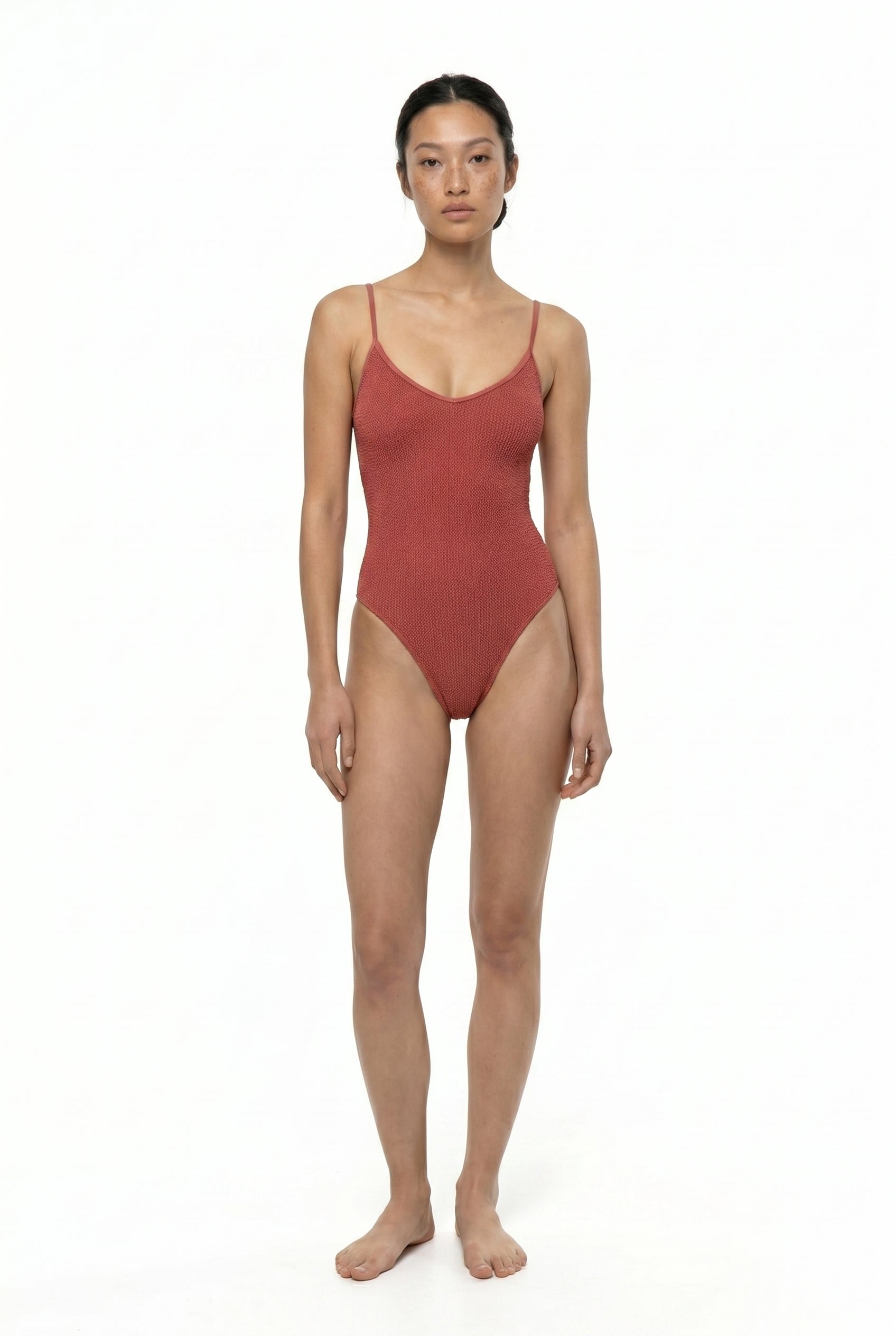 Woman wearing a red swimsuit on a white background