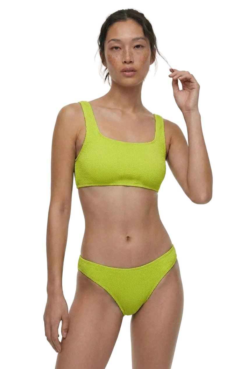 Woman wearing a bright green bikini set on a white background