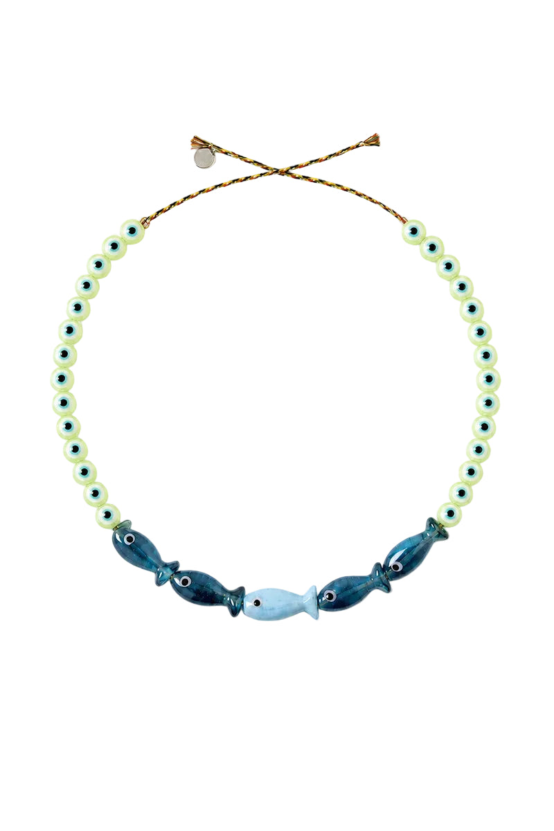 A beaded necklace featuring light green translucent beads with small dark blue dots, accented by three larger decorative beads in shades of blue, navy, and pale blue at the bottom center, suspended on a gold-toned adjustable cord.
