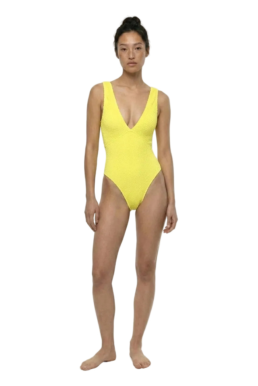 Woman wearing a yellow swimsuit on a white background
