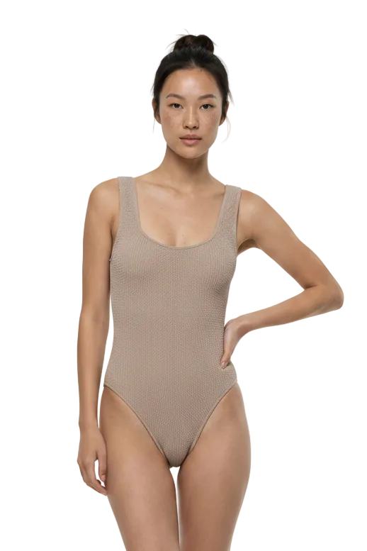 Woman wearing a beige bodysuit on a white background