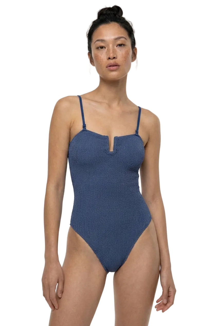 Woman wearing a blue ribbed swimsuit on a white background