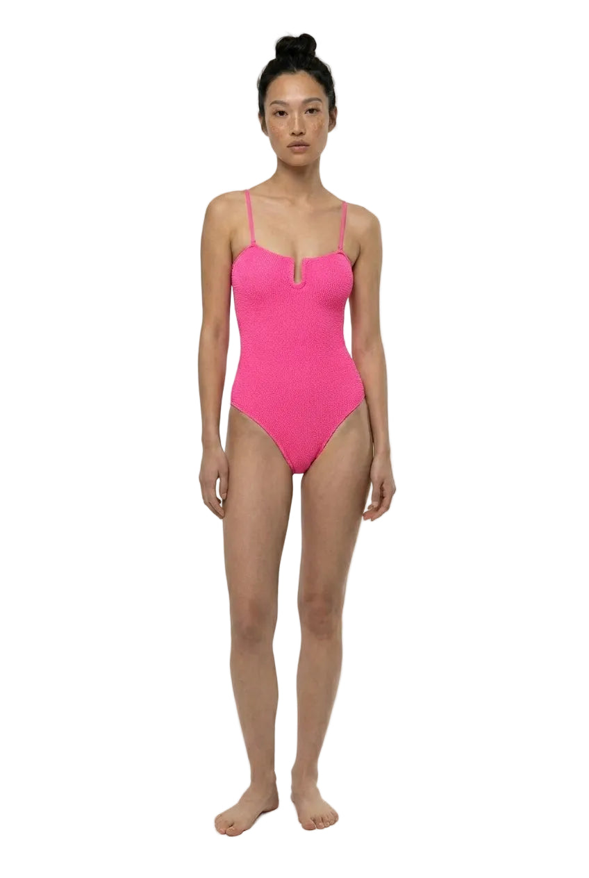 Person wearing a bright pink swimsuit on a white background