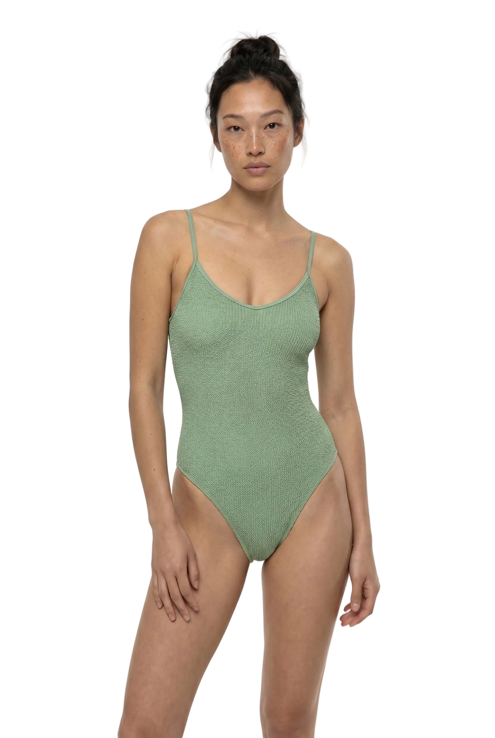 Woman wearing a green swimsuit on a white background