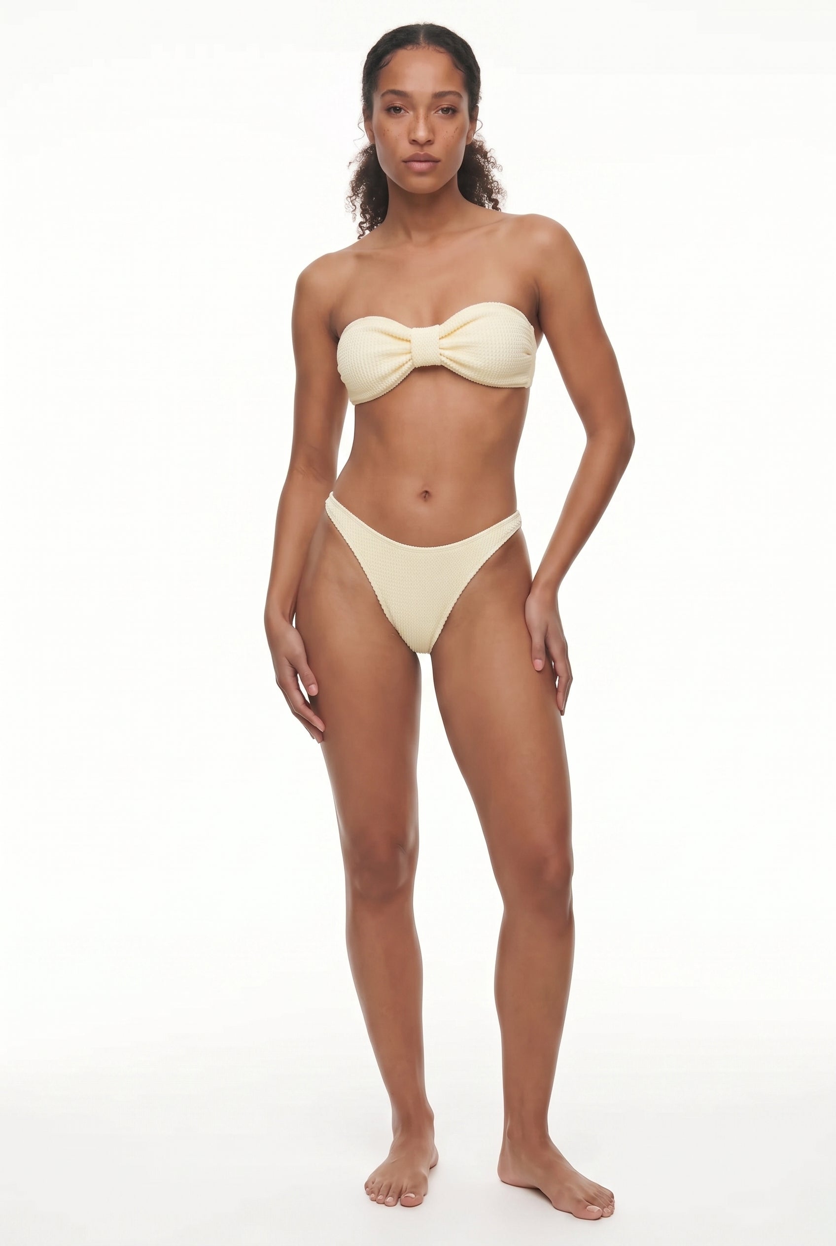 Woman wearing a beige bikini on a white background