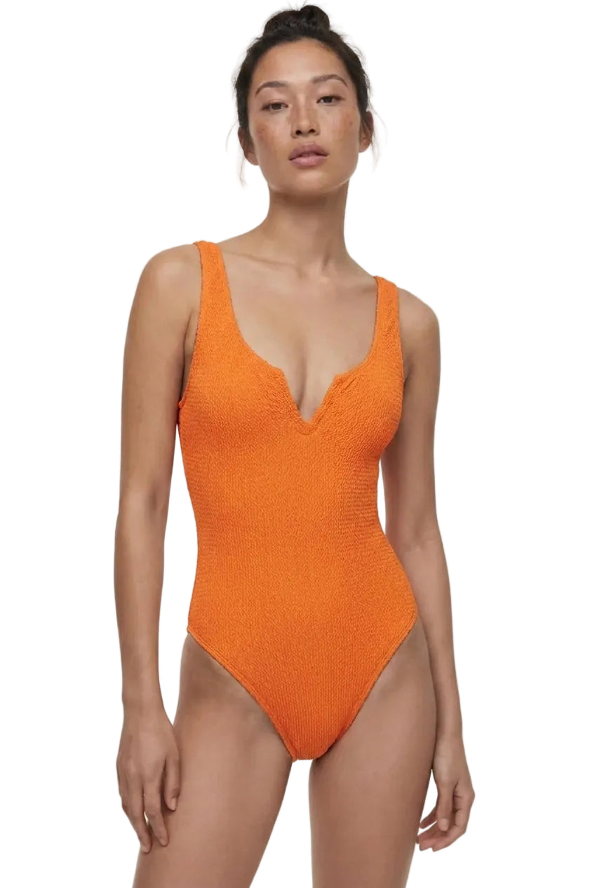 Woman wearing an orange swimsuit on a white background